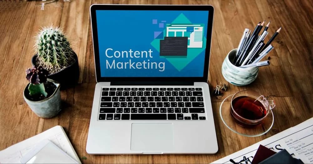 Content strategist analyzing audience data graphs alongside a creative writer drafting compelling copy on a laptop.